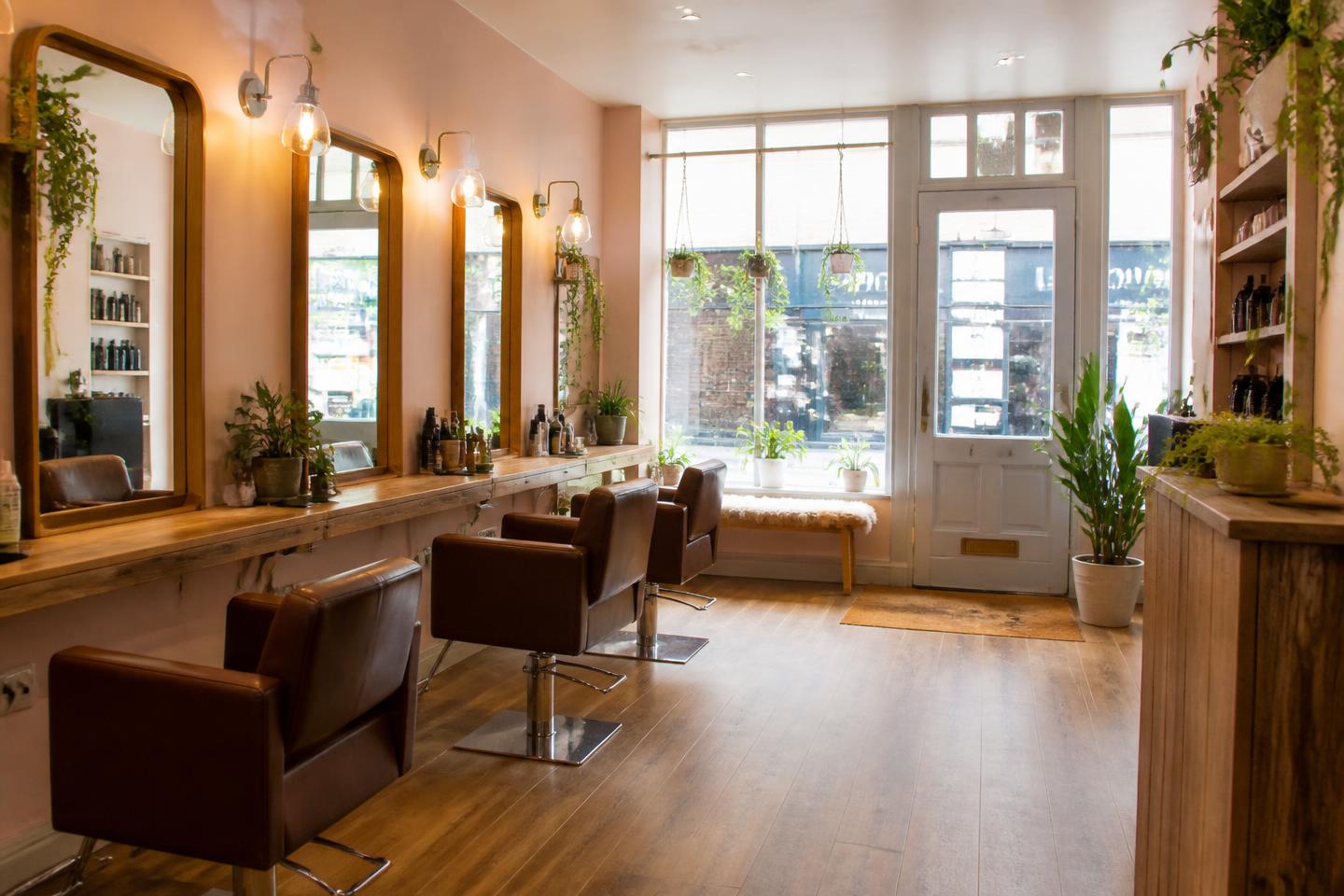 The interior of Mia's salon: styling chairs, mirrors, plants and a bright shopfront window
